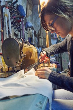 Evde retro dikiş makinesi kullanan bir kadın terzi, hobi konsepti..