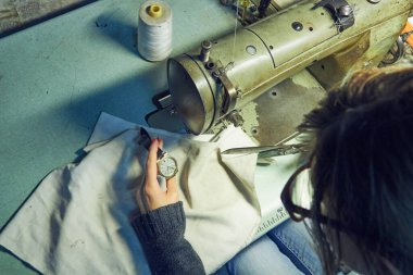 Evde retro dikiş makinesi kullanan bir kadın terzi, hobi konsepti..