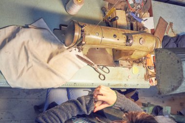 Evde retro dikiş makinesi kullanan bir kadın terzi, hobi konsepti..