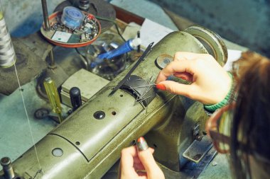 Evde retro dikiş makinesi kullanan bir kadın terzi, hobi konsepti..