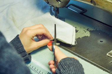 Evde retro dikiş makinesi kullanan bir kadın terzi, hobi konsepti..