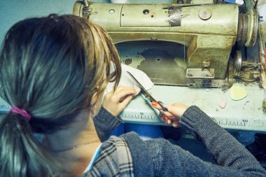Evde retro dikiş makinesi kullanan bir kadın terzi, hobi konsepti..