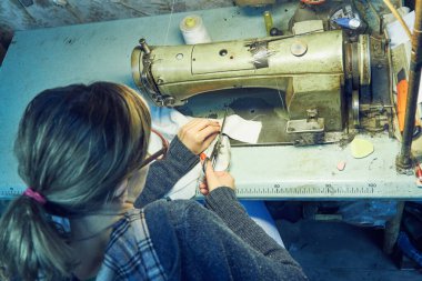 Evde retro dikiş makinesi kullanan bir kadın terzi, hobi konsepti..