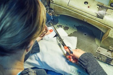 Evde retro dikiş makinesi kullanan bir kadın terzi, hobi konsepti..