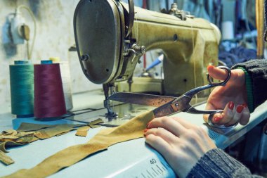 Evde retro dikiş makinesi kullanan bir kadın terzi, hobi konsepti..