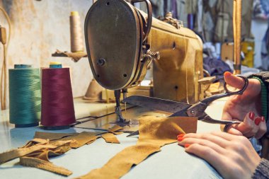 Evde retro dikiş makinesi kullanan bir kadın terzi, hobi konsepti..