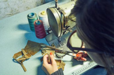 Evde retro dikiş makinesi kullanan bir kadın terzi, hobi konsepti..