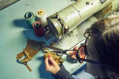 Evde retro dikiş makinesi kullanan bir kadın terzi, hobi konsepti..