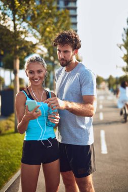 Modern çift koşu / egzersiz sırasında kaldırımda mola veriyor.