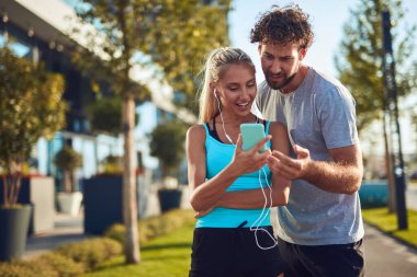 Modern çift koşu / egzersiz sırasında kaldırımda mola veriyor.