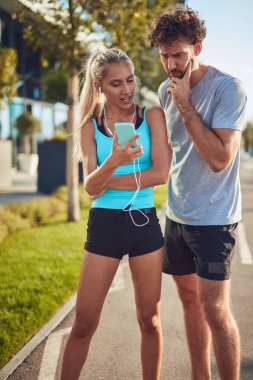 Modern çift koşu / egzersiz sırasında kaldırımda mola veriyor.