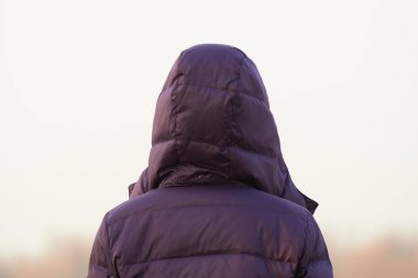 Uzağa bakan ceketli, tanınmayan bir kadın..