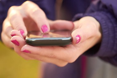 Modern bir akıllı telefon tutan kadınların yakın plan fotoğrafları..