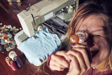 Evde retro dikiş makinesi kullanan bir kadın terzi, hobi konsepti..