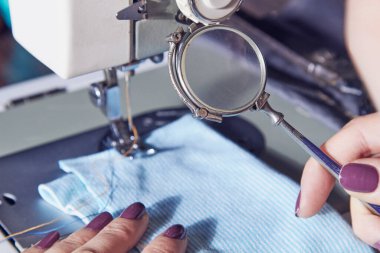 Evde retro dikiş makinesi kullanan bir kadın terzi, hobi konsepti..