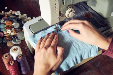 Evde retro dikiş makinesi kullanan bir kadın terzi, hobi konsepti..