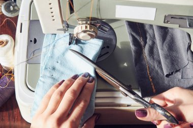 Evde retro dikiş makinesi kullanan bir kadın terzi, hobi konsepti..