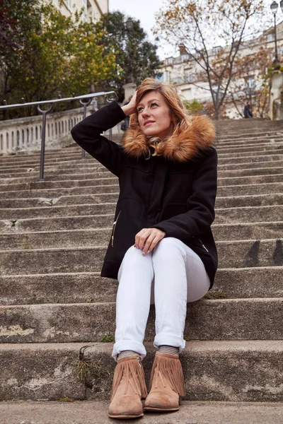 Büyük bir merdivende tek başına oturan tatlı gülen kız..