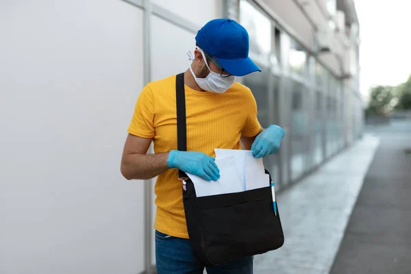大流行期间 邮递员以邮袋 防护面具和手套投递邮件 — 图库照片