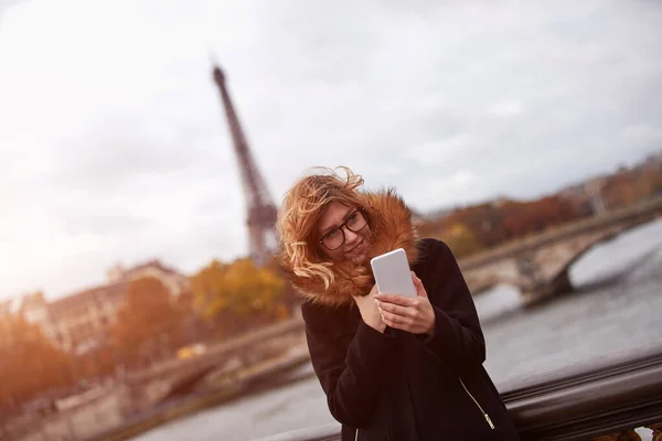 パリ市内の背景を持つ携帯電話を使用して女の子 セーヌ川とエッフェル塔 — ストック写真