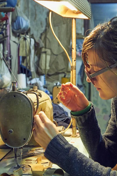 Evde retro dikiş makinesi kullanan bir kadın terzi, hobi konsepti..