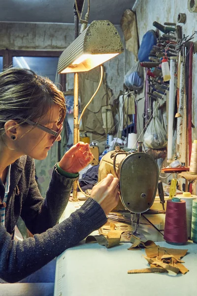 Evde retro dikiş makinesi kullanan bir kadın terzi, hobi konsepti..