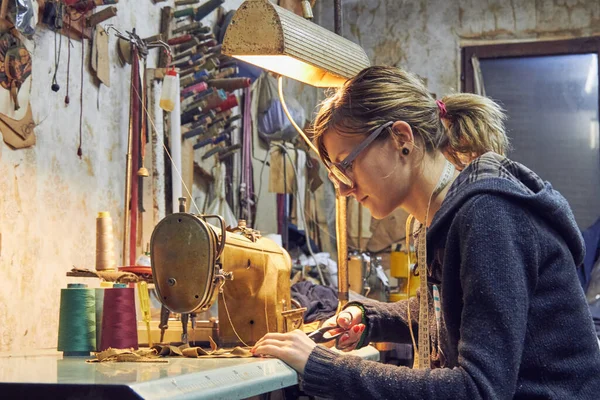 Evde retro dikiş makinesi kullanan bir kadın terzi, hobi konsepti..