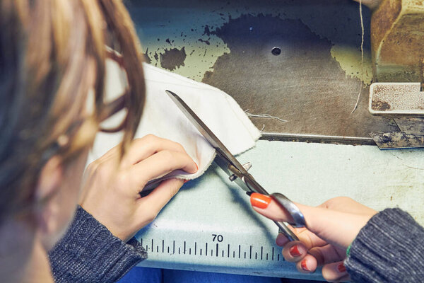 Woman tailor using retro sewing machine at home, hobby concept.