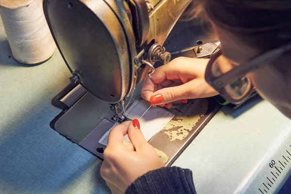 Evde retro dikiş makinesi kullanan bir kadın terzi, hobi konsepti..