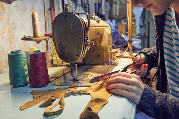 Evde retro dikiş makinesi kullanan bir kadın terzi, hobi konsepti..