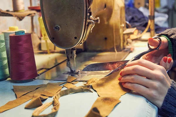 Evde retro dikiş makinesi kullanan bir kadın terzi, hobi konsepti..