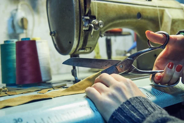 Evde retro dikiş makinesi kullanan bir kadın terzi, hobi konsepti..