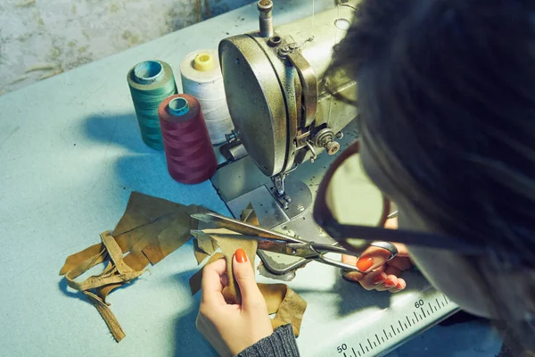 Evde retro dikiş makinesi kullanan bir kadın terzi, hobi konsepti..