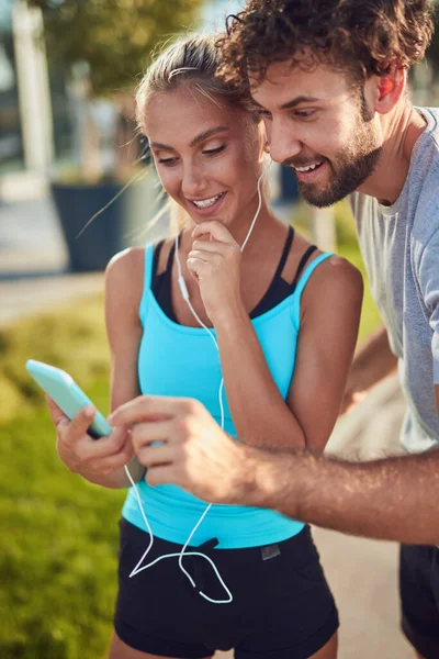 Modern çift koşu / egzersiz sırasında kaldırımda mola veriyor.