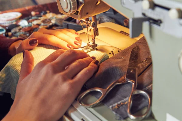 Evde retro dikiş makinesi kullanan bir kadın terzi, hobi konsepti..