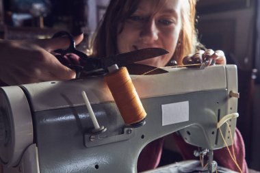 Evde retro dikiş makinesi kullanan bir kadın terzi, hobi konsepti..