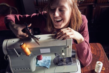 Evde retro dikiş makinesi kullanan bir kadın terzi, hobi konsepti..