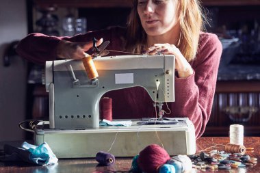 Evde retro dikiş makinesi kullanan bir kadın terzi, hobi konsepti..