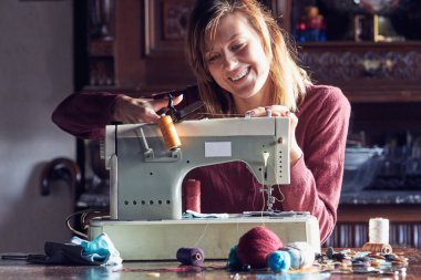 Evde retro dikiş makinesi kullanan bir kadın terzi, hobi konsepti..