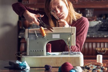 Evde retro dikiş makinesi kullanan bir kadın terzi, hobi konsepti..