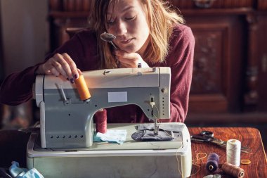 Evde retro dikiş makinesi kullanan bir kadın terzi, hobi konsepti..