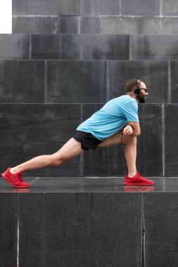 Kentsel çevrede koşma / egzersiz sonrasında modern sporcu durakladı ve gerindi.