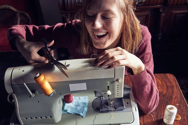 Evde retro dikiş makinesi kullanan bir kadın terzi, hobi konsepti..