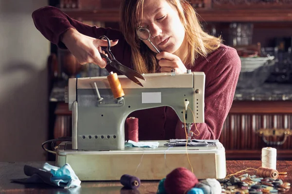 Evde retro dikiş makinesi kullanan bir kadın terzi, hobi konsepti..