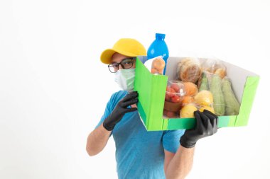 Koruyucu maskeli teslimatçı. Bakkaliye kutusuyla birlikte..