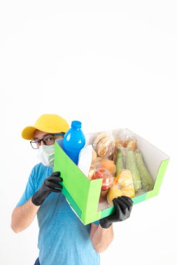 Koruyucu maskeli teslimatçı. Bakkaliye kutusuyla birlikte..