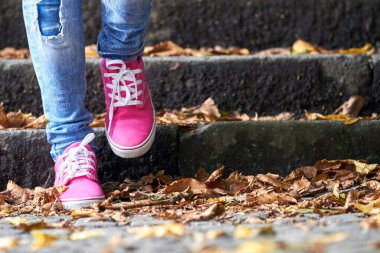 Pembe / mor tuval kumaş ayakkabılı ve kot pantolonlu kadın..