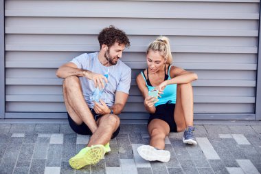 Modern şehir çifti koşu / egzersiz sırasında kaldırımda mola veriyor.