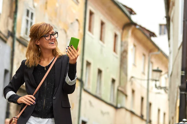 Χαριτωμένη Νεαρή Καυκάσια Γυναίκα Κρατώντας Σύγχρονο Smartphone Στο Δρόμο — Φωτογραφία Αρχείου