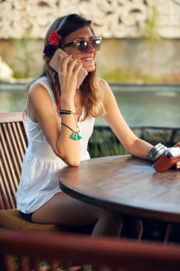 Beyaz kadın yaz mevsiminde bahçe avlusunda cep telefonu kullanıyor..